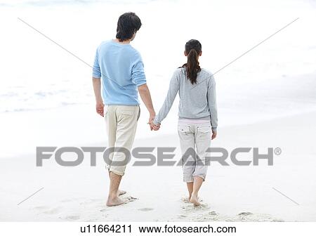 Couple walking barefoot on the beach View Large Photo Image Stock Image - Couple walking barefoot on the beach. Fotosearch