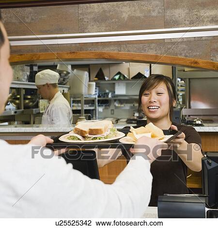 Customer receiving tray of food in bakery View Large Photo Image Stock Image - Customer receiving tray of food in bakery. Fotosearch