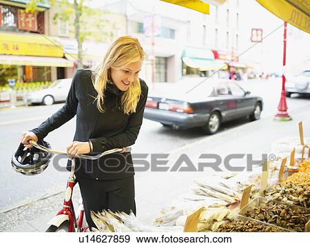 Stock Photo - Cyclist looking at display of fish. Fotosearch