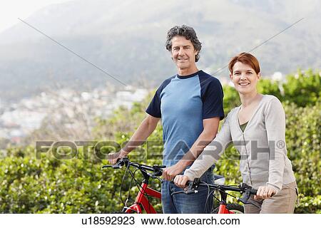 Stock Image - Cyclists standing beside their bikes. Fotosearch