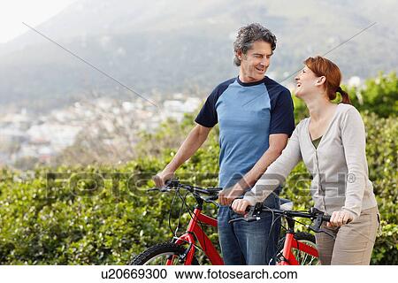 Stock Image - Cyclists standing beside their bikes. Fotosearch