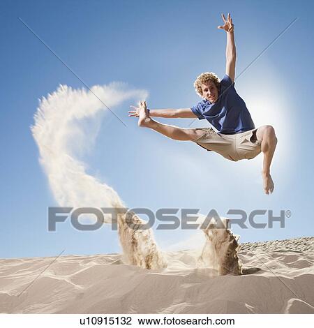 Energetic man jumping in the sand View Large Photo Image Stock Image - Energetic man jumping in the sand. Fotosearch