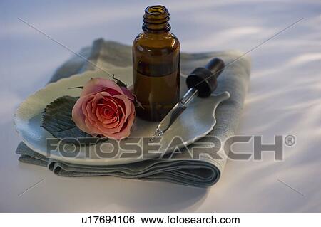 Stock Photograph - Essential oil and rose on tray. Fotosearch