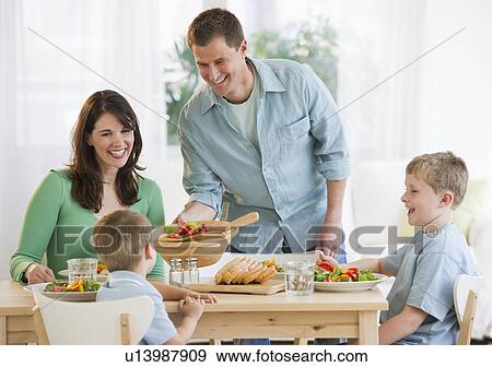 Stock Photo - Family eating dinner. Fotosearch