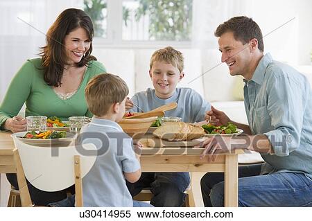 Stock Photography - Family eating dinner. Fotosearch