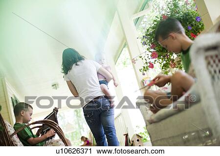 Stock Image - Family on porch. Fotosearch