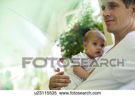 Stock Photography - Father and baby daughter sitting on porch. Fotosearch