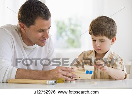 Father and son building a wooden train View Large Photo Image Stock Photograph - Father and son building a wooden train. Fotosearch