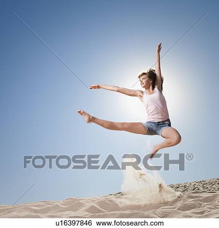 Female dancer jumping in sand View Large Photo Image Stock Photograph - Female dancer jumping in sand. Fotosearch