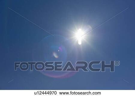 Stock Image - Flare of light in blue sky. Fotosearch
