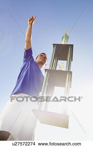 Picture - Football player holding trophy. Fotosearch