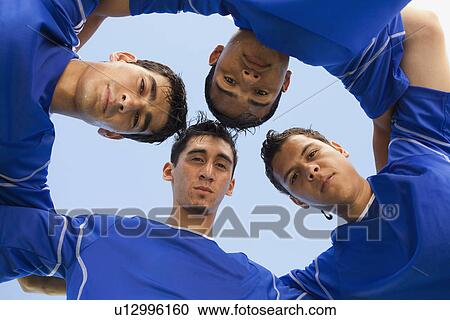 Stock Image - Football players huddled together. Fotosearch