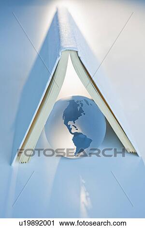 Stock Image - Globe under a book. Fotosearch
