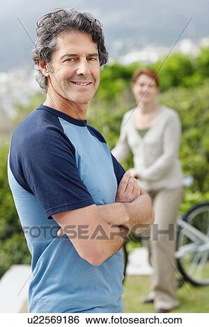 Handsome man standing with his arms crossed View Large Photo Image Stock Photograph - Handsome man standing with his arms crossed. Fotosearch