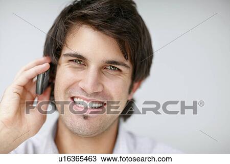 Stock Image - Handsome man talking on cell phone. Fotosearch