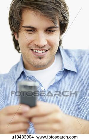 Picture - Handsome man texting. Fotosearch