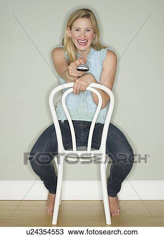 Happy woman holding a remote control View Large Photo Image Stock Image - Happy woman holding a remote control. Fotosearch