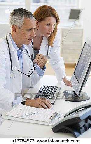Healthcare professionals looking at computer View Large Photo Image Stock Image - Healthcare professionals looking at computer. Fotosearch