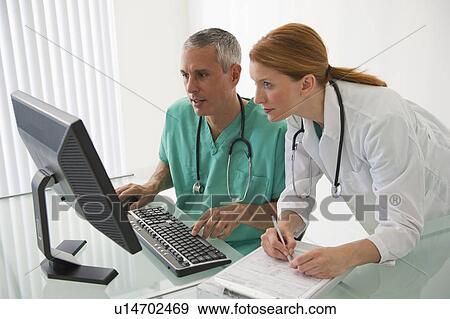 Healthcare professionals looking at computer View Large Photo Image Stock Photo - Healthcare professionals looking at computer. Fotosearch