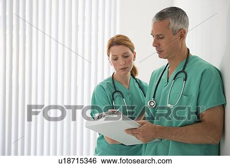 Stock Photograph - Healthcare professionals looking at medical chart. Fotosearch