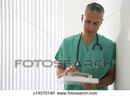Healthcare worker writing on medical chart View Large Photo Image Stock Photo - Healthcare worker writing on medical chart. Fotosearch