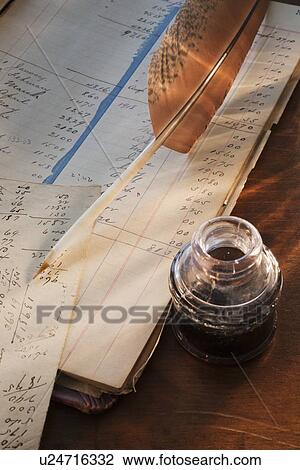 Stock Image - Ink feather pen and ledger. Fotosearch