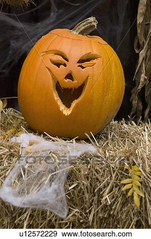 Stock Photo - Jack-o-lantern on bale of hay. Fotosearch