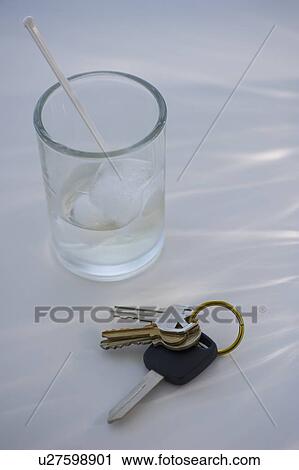 Stock Image - Keys beside alcoholic drink. Fotosearch