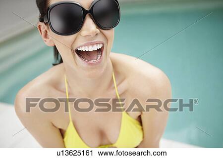 Laughing woman wearing bikini and sunglasses View Large Photo Image Stock Image - Laughing woman wearing bikini and sunglasses. Fotosearch