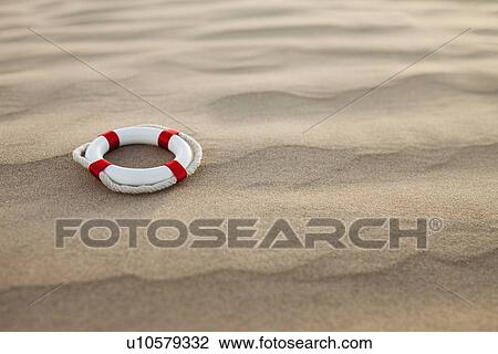 Stock Image - Lifebuoy in desert. Fotosearch