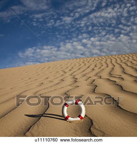 Stock Image - Lifebuoy in desert. Fotosearch