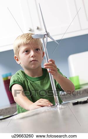Stock Image - Little boy looking at model windmill. Fotosearch