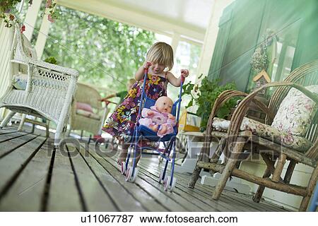 Stock Photo - Little girl pushing doll in stroller. Fotosearch