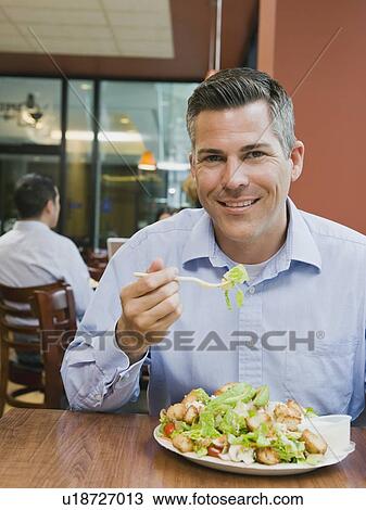 Man eating salad in restaurant View Large Photo Image Stock Image - Man eating salad in restaurant. Fotosearch
