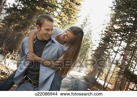 Man giving girlfriend a piggyback ride View Large Photo Image Picture - Man giving girlfriend a piggyback ride. Fotosearch