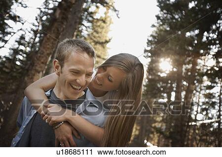 Stock Image - Man giving girlfriend a piggyback ride. Fotosearch