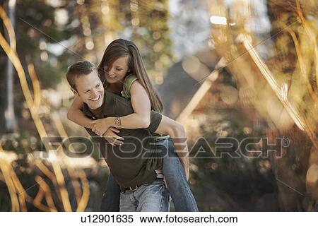 Man giving girlfriend a piggyback ride View Large Photo Image Stock Photography - Man giving girlfriend a piggyback ride. Fotosearch