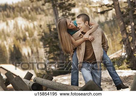 Stock Photography - Man giving girlfriend a piggyback ride. Fotosearch