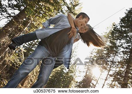 Stock Photography - Man giving girlfriend a piggyback ride. Fotosearch