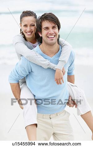 Picture - Man giving woman a piggy back ride. Fotosearch