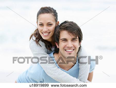 Stock Photo - Man giving woman a piggy back ride. Fotosearch