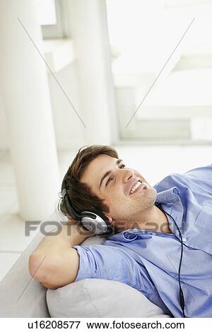 Stock Photo - Man listening to music on headphones. Fotosearch