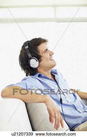 Man listening to music on headphones View Large Photo Image Stock Photo - Man listening to music on headphones. Fotosearch