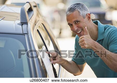 Stock Photo - Man looking at new car. Fotosearch