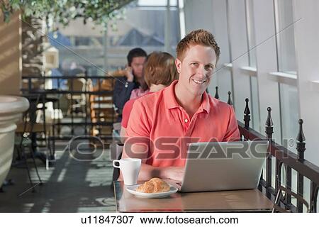 Man sitting on patio at cafe View Large Photo Image Stock Photo - Man sitting on patio at cafe. Fotosearch