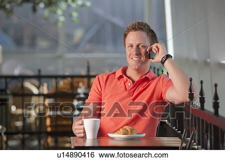 Man sitting on patio at cafe View Large Photo Image Stock Photograph - Man sitting on patio at cafe. Fotosearch