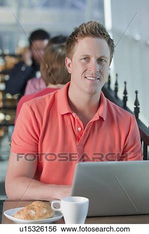 Stock Photograph - Man sitting on patio at cafe. Fotosearch