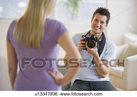 Stock Photograph - Man taking photograph of woman. Fotosearch