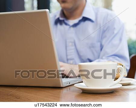Man working on laptop in restaurant View Large Photo Image Picture - Man working on laptop in restaurant. Fotosearch