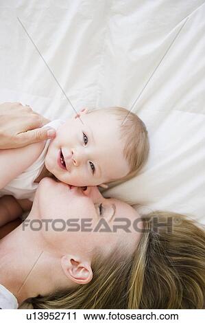 Stock Image - Mother and baby lying down together. Fotosearch